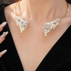 Vue détaillée d'un élégant tour de cou ailes d'ange dorées avec cristaux brillants