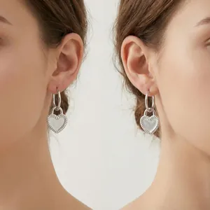 Silver hoop earrings with heart lock charms and fine texture detailing for women