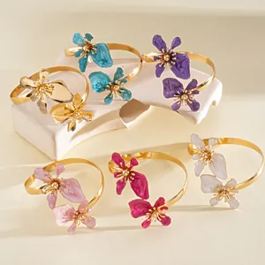 Elegante gouden metalen armmanchetten met levendige emaille bloemmotieven in diverse kleuren