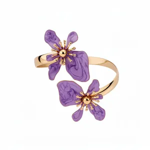 Elegante gouden gedraaide armband met twee paarse emaille bloemen in een minimalistische stijl