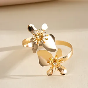 Gedetailleerd zicht op een gouden metalen armring met elegante bloemmotieven en goud.