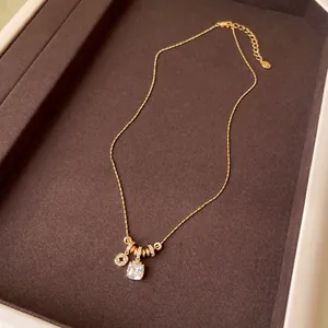 Close-up of elegant 18k gold plated necklace with square zircon and floral charm