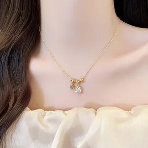 Detail view of an elegant 18k gold plated square zircon pendant necklace on a model's neck
