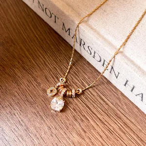 Close-up detail of 18k gold plated necklace with square zircon and floral charm