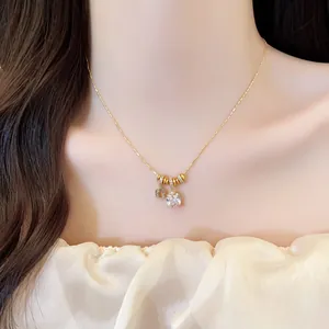 Detailed view of 18k gold plated necklace featuring square cubic zirconia and flower charm.