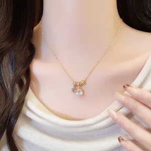 Detailed view of a gold-plated necklace with a square zircon and flower pendant.