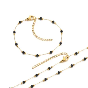 Minimalist stainless steel necklace and bracelet set with faceted black beads on white background