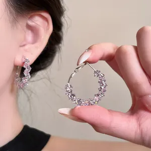 Close-up of elegant hoop earrings adorned with pink sparkling zircons