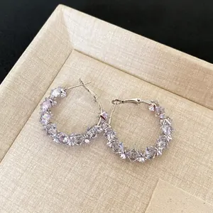 Detail view of elegant silver hoop earrings with sparkling clustered clear crystals.