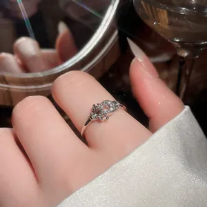 Primo piano di un delicato anello d'argento con motivo a ferro di cavallo tempestato di diamanti