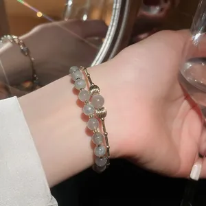 Vista ravvicinata di un bracciale a doppio strato placcato oro 18k con perle di pietra di luna
