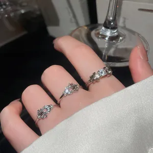 Primo piano di tre anelli scintillanti in argento e cristallo su uno sfondo di lusso