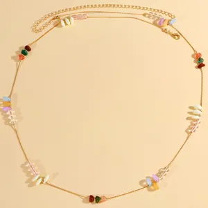 Exquisite detail of a bohemian gold-toned waist chain featuring irregular colorful stone beads.
