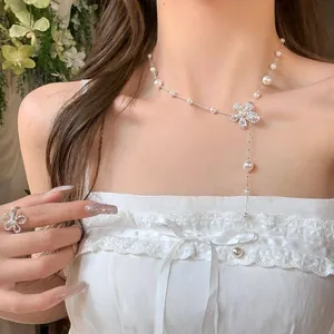 Vista dettagliata di un'elegante collana di perle a fiori e anello coordinato su una modella