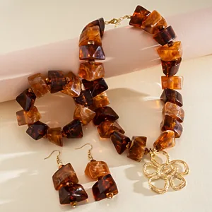 Detailansicht von Vintage Bernstein Acryl Schmuckset mit geometrischen Perlen und Blume.
