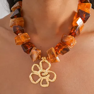 Detailansicht einer Vintage-Halskette mit bernsteinfarbenen Perlen und Goldblumenanhänger