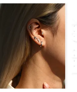 Close-up of S925 sterling silver moissanite stud earrings on ear.