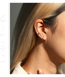 Close-up detail of moissanite S925 sterling silver stud earrings on model's ear