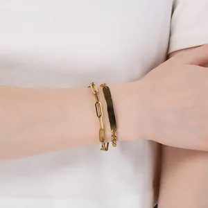 Close-up detail shot of a double-layer gold stainless steel bracelet worn on the wrist