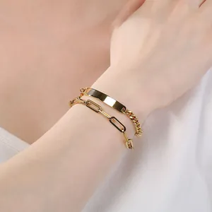 Close-up of minimalist double-layer gold titanium steel bracelet with engravable bar