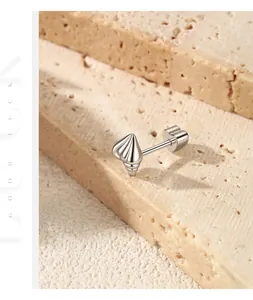 Close-up of S925 sterling silver screw stud earring on textured stone background