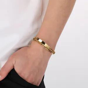 Detailed view of a gold-toned stainless steel multi-layer Cuban chain bracelet on a wrist