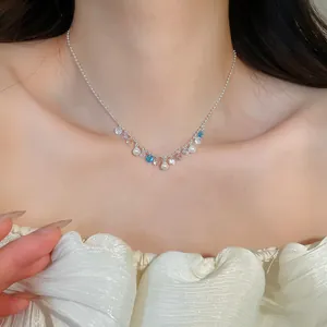 Detailed view of silver necklace with colorful zircons and pearls on a model's neck
