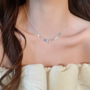 Close-up detail of elegant rainbow zircon and pearl choker necklace on model's neck.
