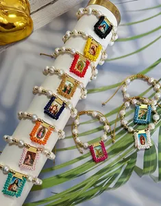 Detailed view of colorful handmade religious pearl bracelets with sacred heart charms.