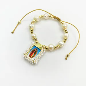 Detailed view of the Virgin of Guadalupe pendant on a handmade natural pearl bracelet.