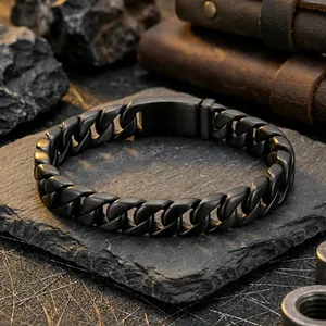 Matte black titanium steel Cuban chain bracelet for men on a dark industrial rock background