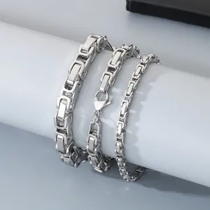 Vista macro de tres anchos de pulseras de cadena bizantina de acero inoxidable para hombres.