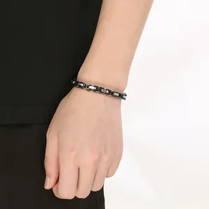 Primer plano de una pulsera bizantina de acero inoxidable para hombre en la muñeca