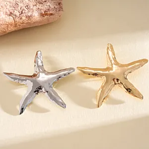 Dettaglio ravvicinato delle spille a stella marina in metallo stropicciato oro e argento