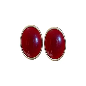 Orecchini a perno vintage ovali in resina rossa con montatura dorata in stile francese.