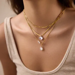 Dettaglio della collana a strati in titanio placcato oro 18k con ciondoli in zirconia