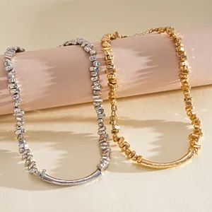 Detailaufnahme der unregelmäßigen geometrischen Metallperlenketten in Gold und Silber