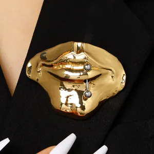 Einzigartige surrealistische goldene Lippenbrosche mit silbernem Piercing-Detail auf Blazer