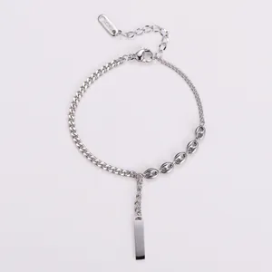 Détail d'un bracelet en chaîne argenté avec pendentif barre lisse et maillons nez de cochon.