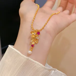 Elegante collar chapado en oro de 24k con colgantes florali, circonitas y detalle de perla.