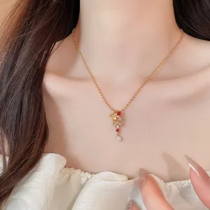 Detalle del collar con colgante floral bañado en oro de 24k con circonitas y perla