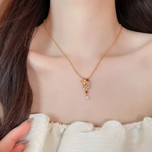 Primer plano de elegante collar con colgante de flor dorada con circonitas y perla en modelo