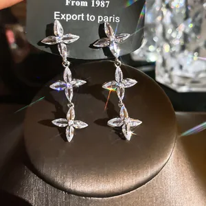Vue détaillée des boucles d'oreilles pendantes à fleurs en cristal marquise étincelant.