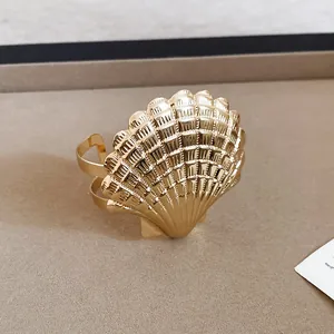 Nahaufnahme einer eleganten goldfarbenen Muschel-Armspange mit feiner Metalltextur