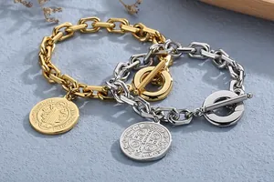 Close-up of gold and silver cuban link bracelets with embossed Saint Benedict medal charms.
