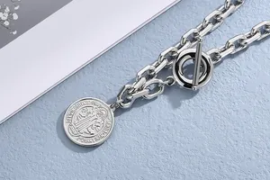 Close-up of vintage titanium steel coin pendant and toggle clasp on chunky chain