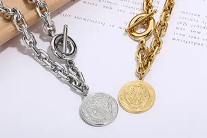 Detail view of retro embossed coin pendants on thick Cuban chain necklaces in gold and silver.