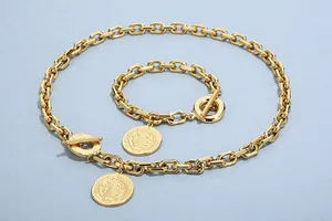 Detail of vintage gold Cuban chain jewelry set with double-sided relief round pendants.