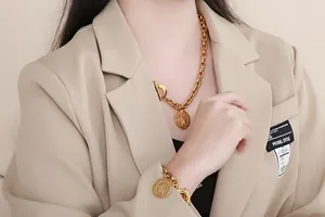 Close-up detail of retro embossed gold pendant on coarse Cuban chain jewelry set