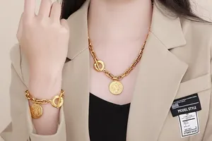 Close-up of retro gold-plated Cuban chain necklace and bracelet with round coin pendant